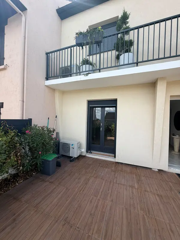 Façade et terrasse de la maison, groupe extérieur en pied de mur