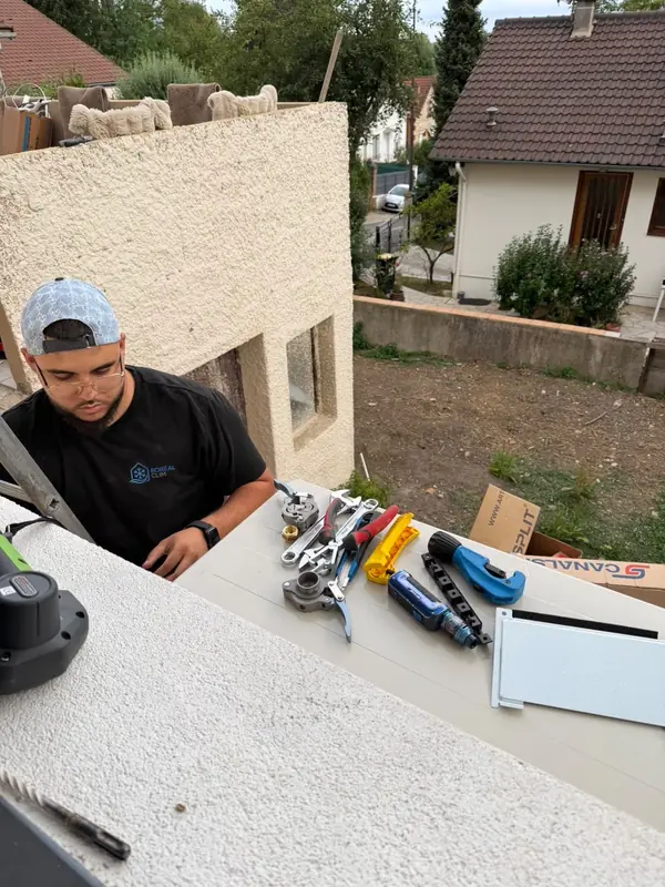 Technicien préparant les goulottes avant la pose